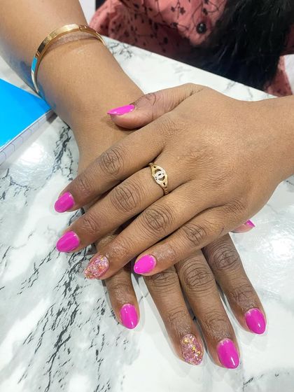 A simple and fun set of bright pink nails with a single gold glitter accent nail.