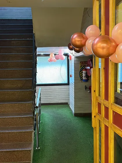 The entrance to the anniversary party venue, decorated with pastel and chrome balloon bunches to welcome the guests.