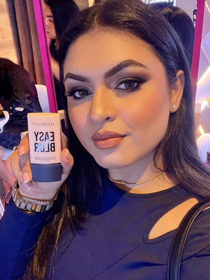Holding the new Huda Beauty Easy Blur foundation at the launch event.