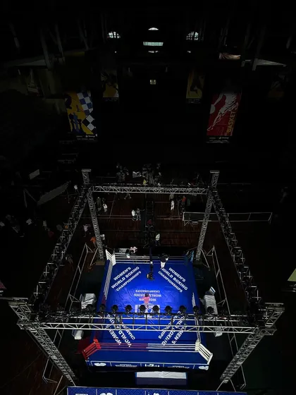 A dramatic top-down view of the boxing ring set up for the Women's World Boxing Championships. This highlights how our space is transformed into a professional combat sports arena, focusing all attention on the action in the center.