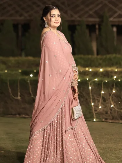 A graceful pose in an outdoor setting. The makeup looks beautiful in the soft evening light.