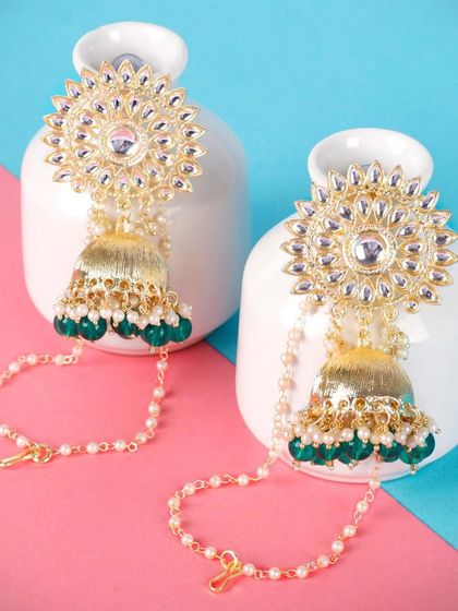 These jhumkas with an attached ear chain, or Saharay, offer extra support and a regal look. This green pair is perfect for brides who want a complete, traditional look.