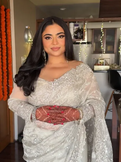 A full view of the elegant ivory saree look. The makeup remains flawless and radiant, enhancing her natural beauty.