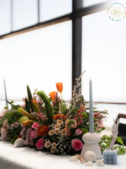 A tablescape by the sea, combining fresh flowers with seashells and coral for a chic, coastal-inspired look.