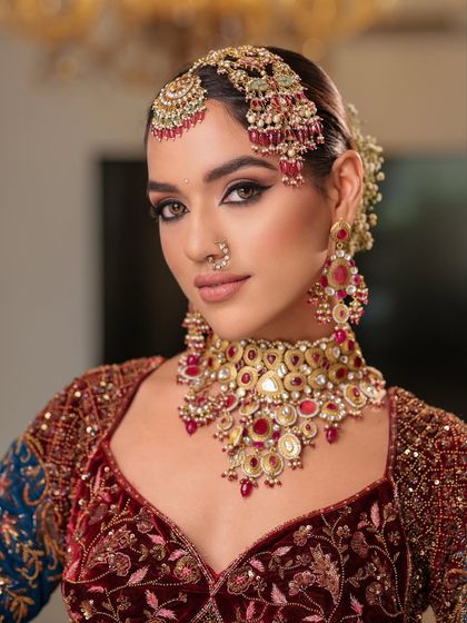 A direct gaze that captures the intensity and beauty of the bridal makeup. The eyes are the centerpiece of this traditional look.