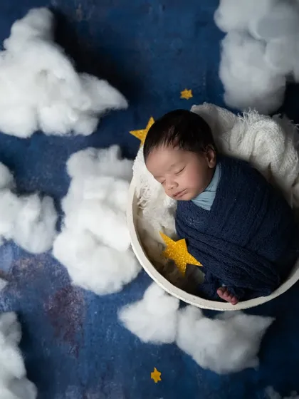An overhead shot of the starry night theme, showing the baby curled up in a moon-shaped bowl, surrounded by glittering stars.