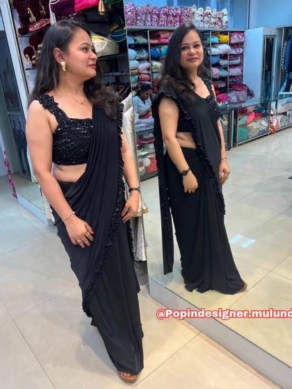 This mirror shot shows the black ruffled saree from both the front and back, highlighting the flattering fit of the sequined blouse and the elegant fall of the drape.