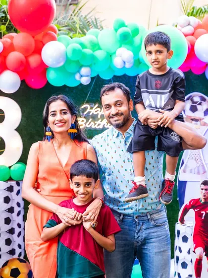A vibrant family portrait from an 8th birthday party with a football theme and colorful decorations.