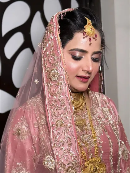A close-up of the eye makeup, featuring soft pink and brown tones with a sharp winged liner for a defined, elegant look.