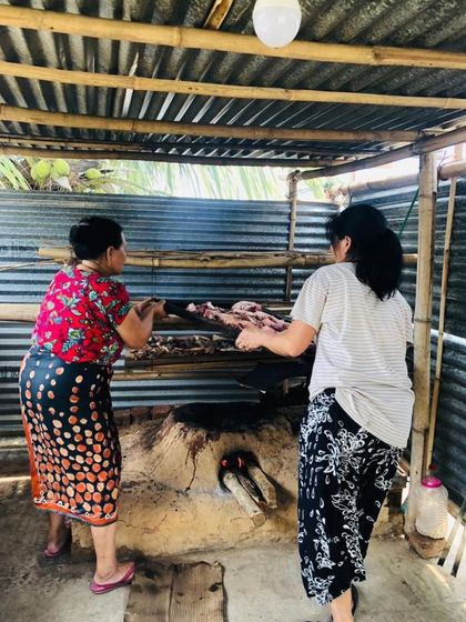 Two women tend to the pork smoking over a traditional earthen stove in Nagaland. This is a community effort and a skill that ensures our food remains authentic to its roots.