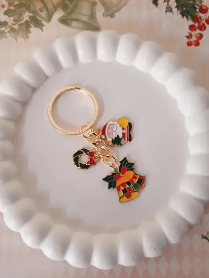A festive keychain featuring Santa, a wreath, and jingle bell charms. It's a perfect stocking stuffer or a cute accessory for your keys during the holidays.