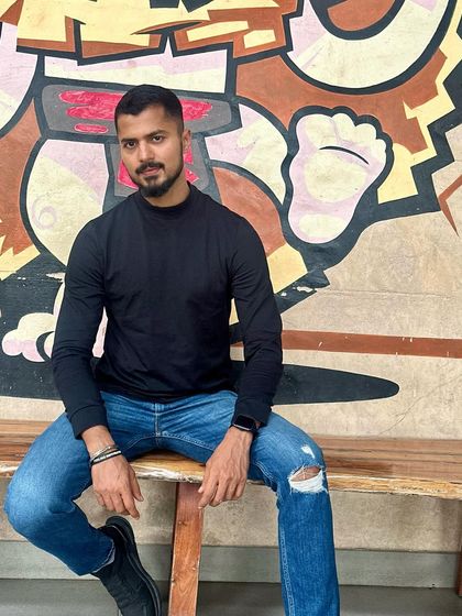 A confident and cool pose in a simple black long-sleeve and ripped jeans.