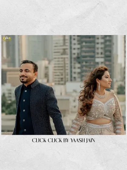 A wide shot of the couple against the city skyline, capturing the urban and modern feel of their rooftop sangeet.