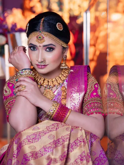 A seated portrait that exudes elegance. The makeup is glamorous, with a focus on the eyes.