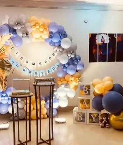 A sophisticated 'Welcome Home Baby Boy' setup. This decoration uses a beautiful color palette of pastel blue, orange, and gold, with dried floral elements for a modern touch.