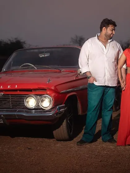 A classic pose with a vintage red car, this pre-wedding photo has a cool, retro vibe that stands out.
