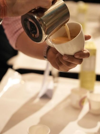 A close-up shot of a student practicing their latte art pour. Precision and a steady hand are skills we help you develop.