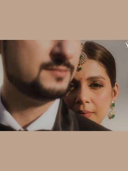 An artistic and intimate close-up of the bride looking over the groom's shoulder. This shot, taken at a Mumbai wedding, is full of emotion and has a cinematic quality.