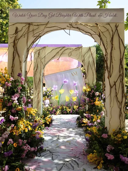 A full view of the whimsical floral entrance arch, creating a magical pathway for the couple and their guests.