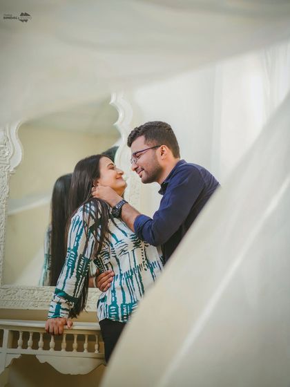 A sweet, tender moment shared in front of a mirror. The soft lighting and genuine smiles make this a perfect example of capturing authentic affection.