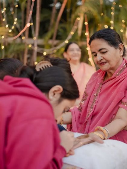 A sweet, tender moment during the Mehendi ceremony. Our planning ensures that families can relax and fully participate in these beautiful traditions and create cherished memories.