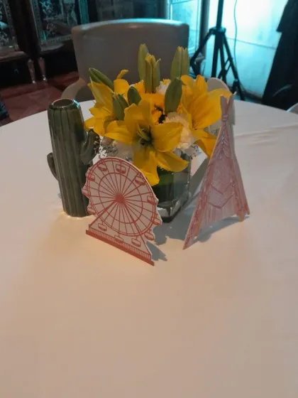 It's all in the details. This "Babychella" themed table centerpiece includes fresh flowers and custom-cut props like a ferris wheel and a teepee, perfectly matching the party's vibe.