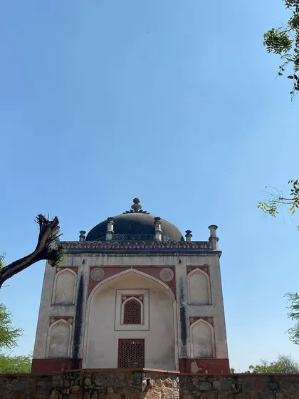 A standalone tomb, or 'gumbad', in Sunder Nursery against a clear blue sky. The park contains over 20 heritage monuments.