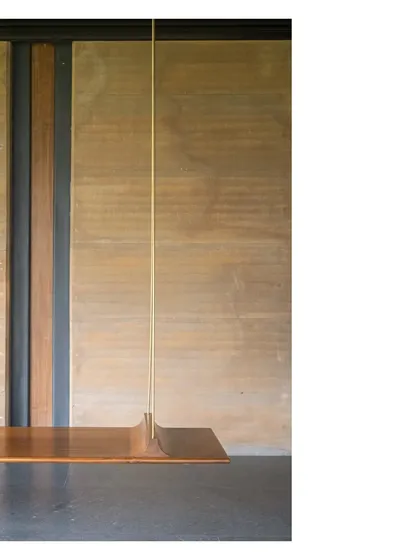 Details make architecture. This suspended swing at the Lakeshore house, crafted from wood and aged brass against a rammed earth wall, is about the feeling of a space. It is about tactile comfort and the simple joys.