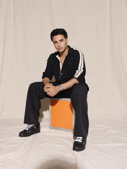 The full look for Abhishek Sharma. The striped shirt paired with black trousers and sneakers is a classic combination that always works.