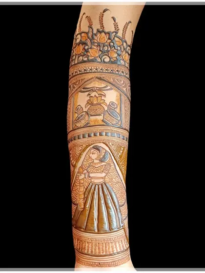 This design showcases a bride holding a kalash, a symbol of prosperity, on her arm. It’s a beautiful way to incorporate blessings into your bridal henna.
