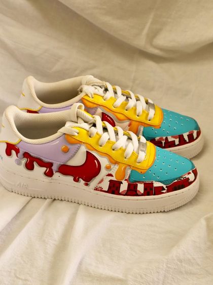 The drip is real. This colorful design on a pair of Nike Air Force 1s features multiple layers of dripping paint in different colors, creating a playful and artistic look.
