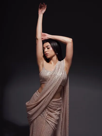 A graceful, expressive pose with arms raised. This shot captures a sense of freedom and movement, adding a dynamic quality to the elegant saree.