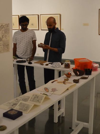 Visitors examining the intricate details of Mohit Mahato's installations and drawings in 'Bring me Flowers'.