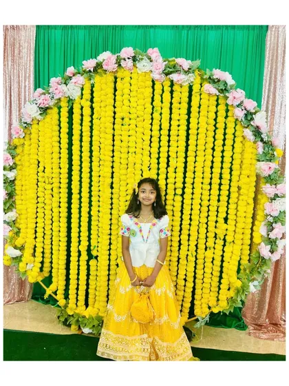 Looking bright and sunny for a celebration. This custom yellow lehenga is paired with a white blouse featuring delicate floral maggam work.