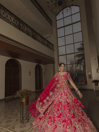 Another angle of the bride's stunning red lehenga, capturing her in motion. The movement adds life and energy to the portrait.