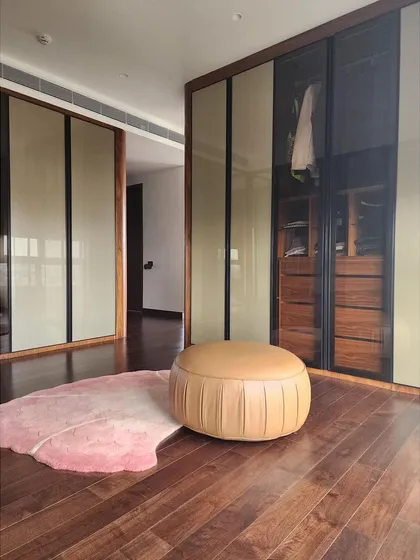 This expansive walk-in closet was created by combining two bedrooms. We used glass and wood sliding doors to create a boutique-like feel, with custom drawers, shelves, and lighting to organize and display the client's collection beautifully.