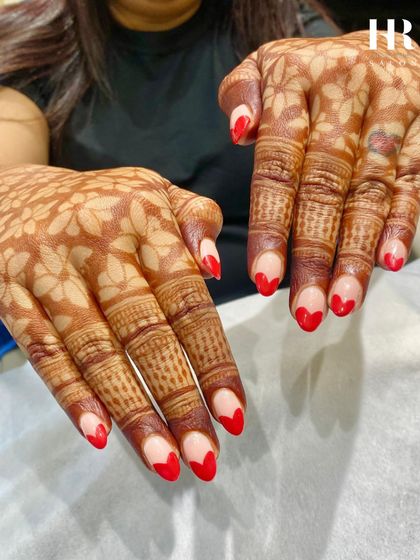 The perfect nails to complement beautiful bridal henna. These nails feature a playful red heart-shaped French tip, adding a pop of colour and a touch of romance to the traditional look.