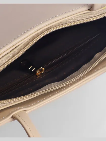 A close-up of the interior zipper and lining of a beige handbag. Detail shots like this build trust and justify a premium price.