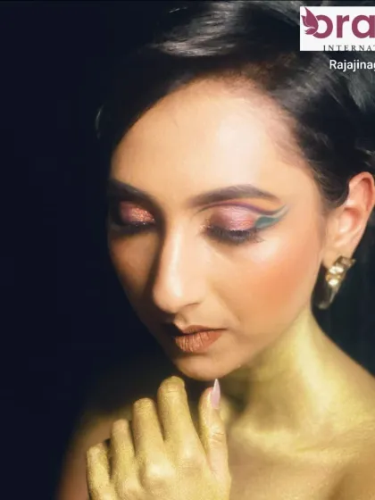A high-fashion magazine look with creative, colorful graphic eyeliner and metallic gold body paint.