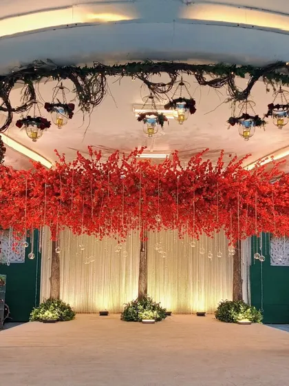 This Navjote ceremony stage is a celebration of tradition with a bold, dramatic flair. The vibrant red floral installation creates a powerful focal point, beautifully contrasted with the surrounding decor to honor this significant cultural milestone.