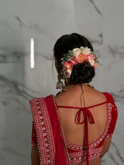 A classic bridal bun, beautifully decorated with fresh roses and baby's breath.