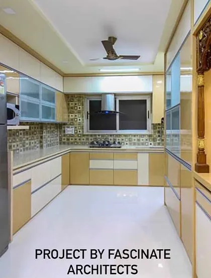 This spacious L-shaped kitchen in a Vashi row house combines beige and white cabinets for a warm, classic look. The design thoughtfully incorporates a dedicated pooja unit, blending spiritual and functional spaces.