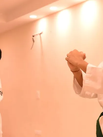 Two students execute a pattern in unison, their focus unwavering during the exam.