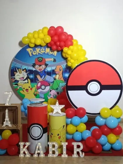 A wider view of the Pokemon party setup, showing the large Pokeball prop next to the main display.