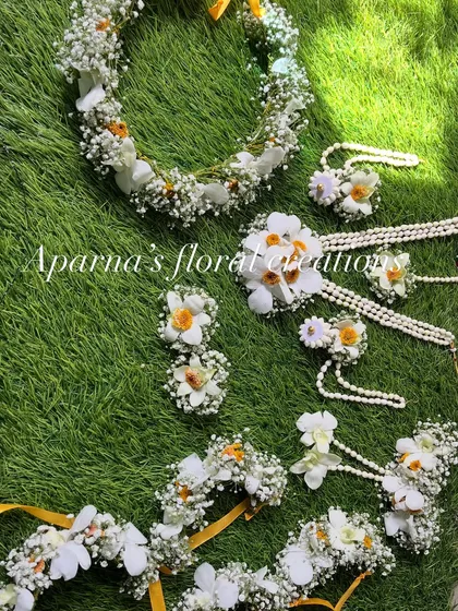 A full view of the white and yellow floral set. It includes a tiara, necklace, earrings, and haath phool.