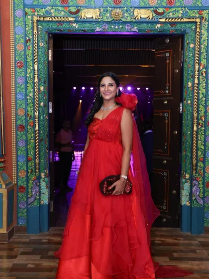 Our client Payal looking exquisite in her dream anniversary gown, a bespoke red one-shoulder dress with a voluminous organza skirt.