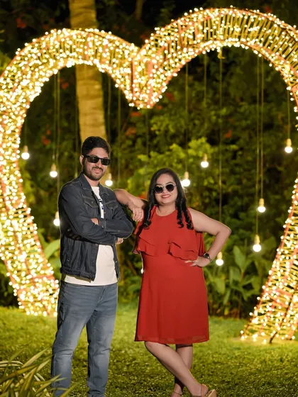 A cool and stylish couple poses in front of the glowing heart prop, showing off their personality.
