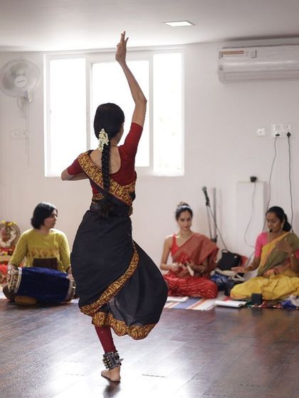 A student practices her movements while the orchestra rehearses. Our studio sessions often include live music, preparing dancers for the experience of a full performance.