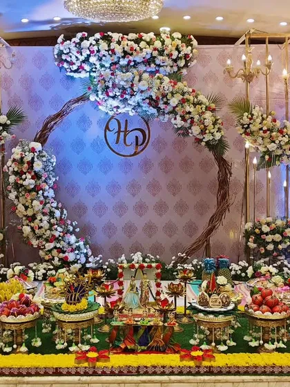 A beautiful engagement setup with a floral ring backdrop and elegant chandeliers. The plate decoration is arranged symmetrically, creating a harmonious and romantic setting.