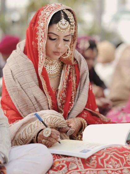 A candid moment from a traditional Sikh wedding ceremony. The bride's makeup is designed to be soft and radiant, perfect for a day-time Anand Karaj, ensuring she looks fresh and beautiful throughout the rituals.